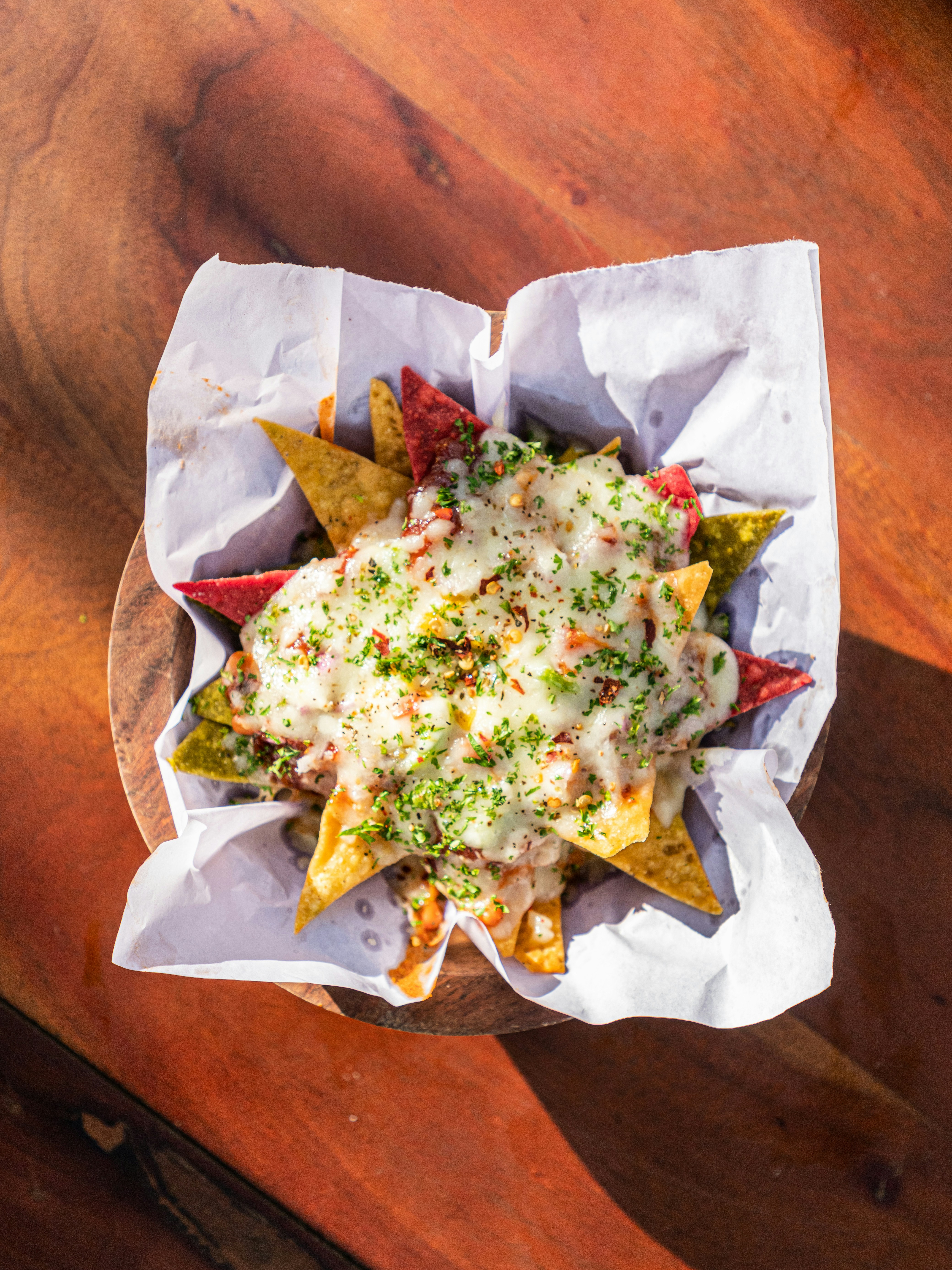 Loaded nachos topped with cheese and fresh garnishes